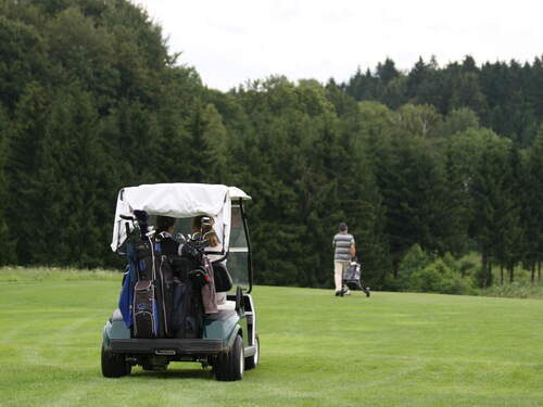 Ein Golfer fährt im Golfwagen über das Gras im Golfclub Bayerischer Wald.
