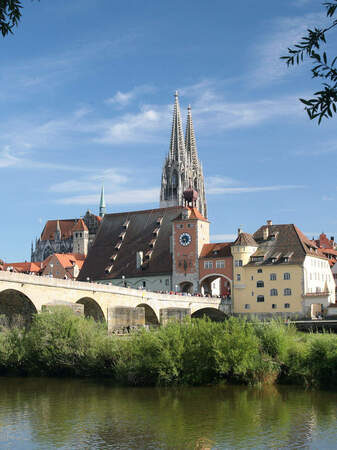 Eine malerische Steinbrücke überspannt den Fluss vor der Altstadt von Regensburg.