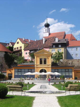 Mehrere Häuser in Schärding, eingebettet in die grüne Natur des Orangerieparks, perfekt für einen erholsamen Spaziergang.